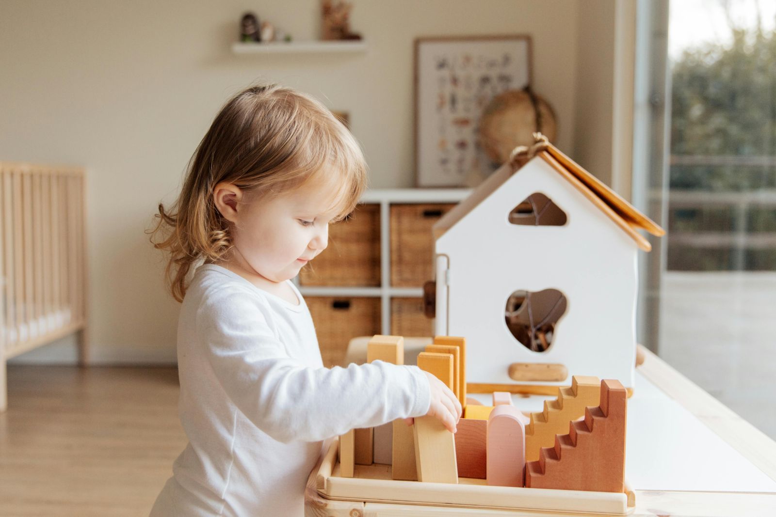 дитина грається з ляльковим будинком